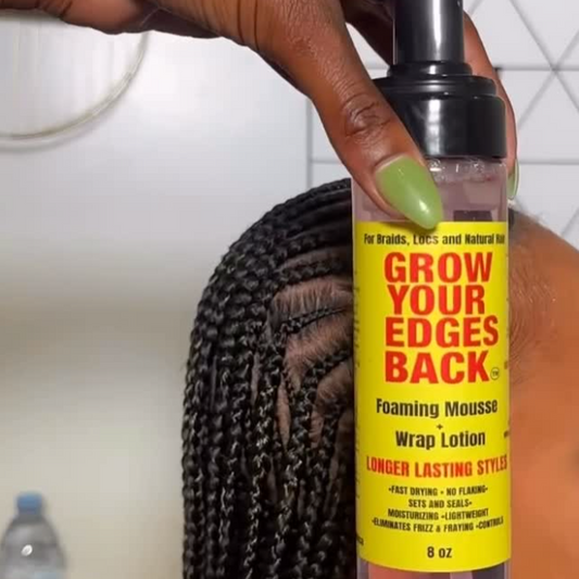 Hand holding Grow Your Edges Back Foaming Mousse and Wrap Lotion beside long braided natural hair