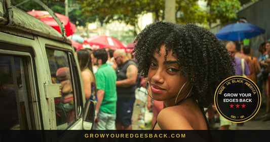 Woman with defined coily natural curls and large hoop earrings at an outdoor street festival, market umbrellas and a crowd behind her in humid air