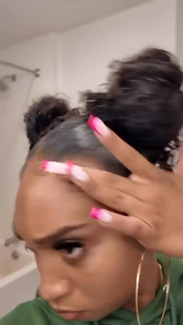 Black woman applying edge control along her own hairline with her fingertips