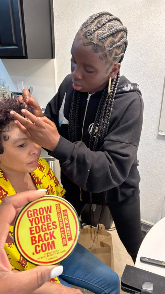 Braider applying product to a client's hairline during a braiding session