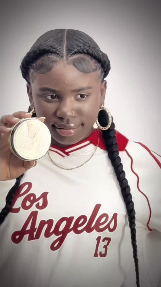 Customer with long braids holding a jar of Grow Your Edges Back Edge Control