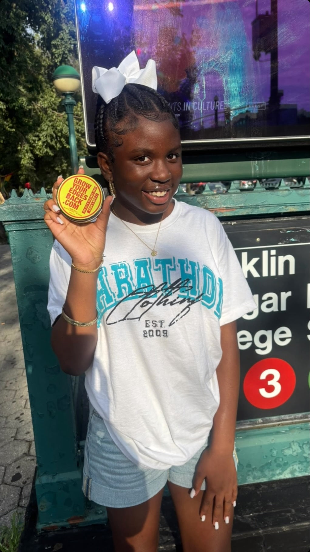 Grow Your Edges Back customer outdoors holding a jar of Edge Control