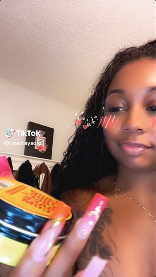 Latina customer holding Grow Your Edges Back products at her styling station