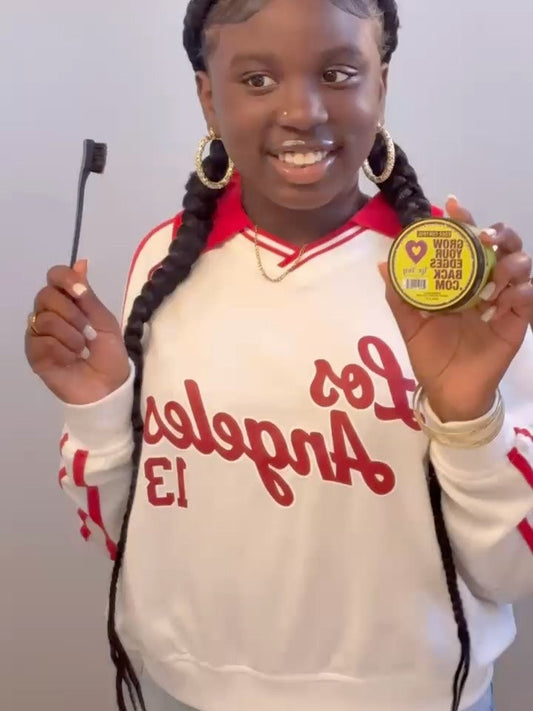 Smiling customer holding a jar of Grow Your Edges Back Edge Control
