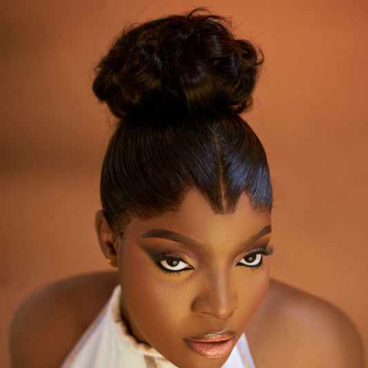 Black woman with a high snatched bun and slicked edges along her hairline