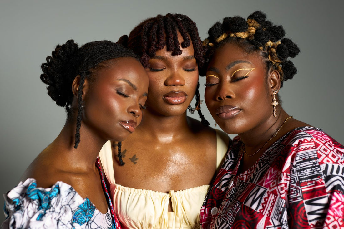Three Black women together wearing different natural textured hairstyles