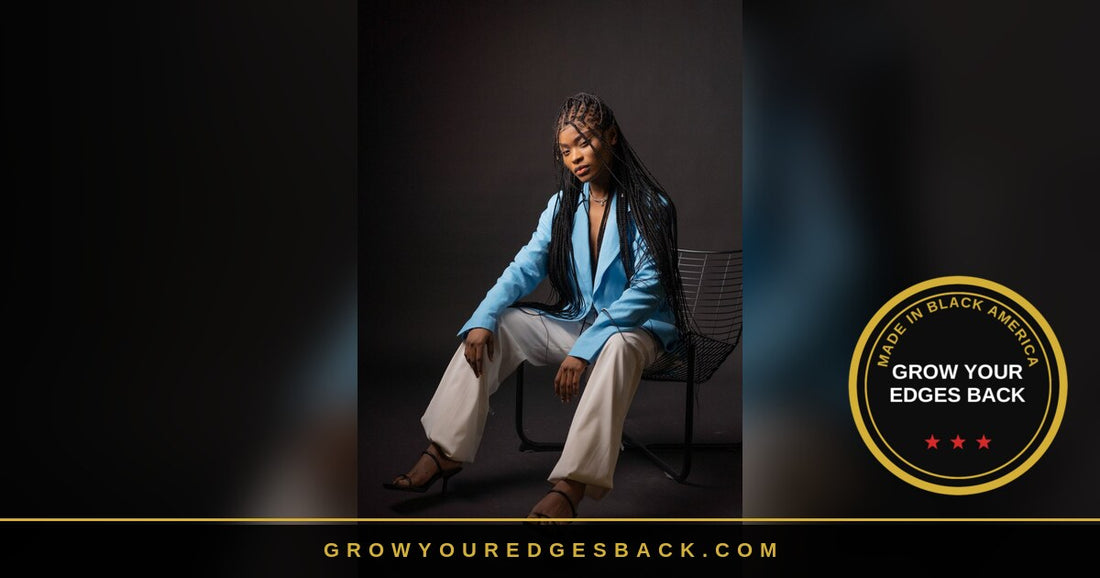 Black woman with long box braids in a light blue blazer and white trousers seated on a chair, Made in Black America by Grow Your Edges Back