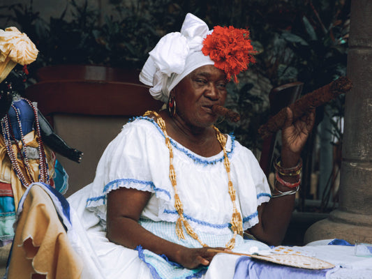 Afro-Cuban woman in traditional dress smoking a cigar, Havana, Cuba - Pexels photo by Mehmet Turgut Kirkgoz