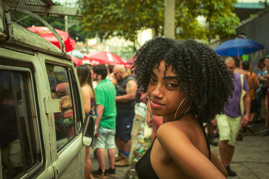 Woman with natural curly coily afro hair smiling at an outdoor Labor Day gathering