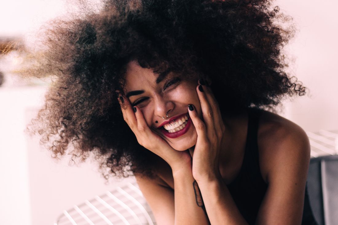 Joyful Black woman with full natural curls - how long does it take for edges to grow back, Grow Your Edges Back