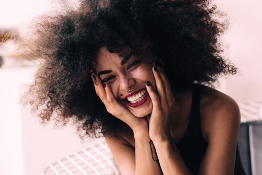 Joyful Black woman with healthy natural curls after traction alopecia regrowth - Grow Your Edges Back