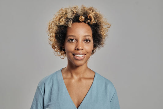 Smiling Black woman with healthy curly natural hair — thinning edges after 40 and menopause, Grow Your Edges Back