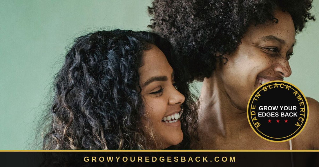 Two women laughing together against a soft green backdrop. The woman in front has long dark curly hair falling past her shoulders, with her hairline and the fine baby hairs at her temple clearly visible.